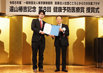 「日本での新型コロナウイルス感染症と血栓症を調査するタスクフォース」代表の山下侑吾氏（左）に授与。右は当法人・医療法人の山田匡通理事長